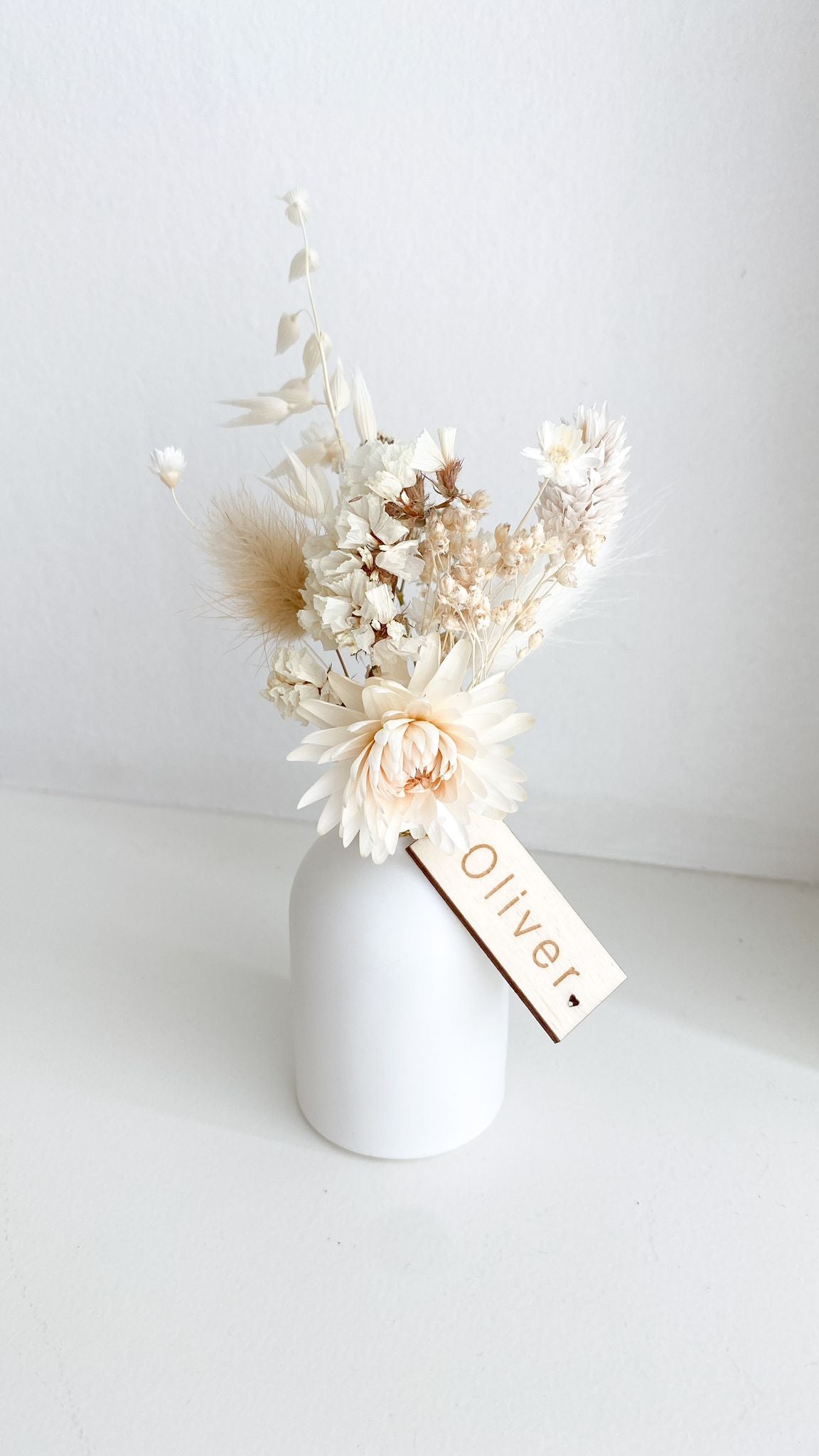 Vaasje met droogbloemen en houten label